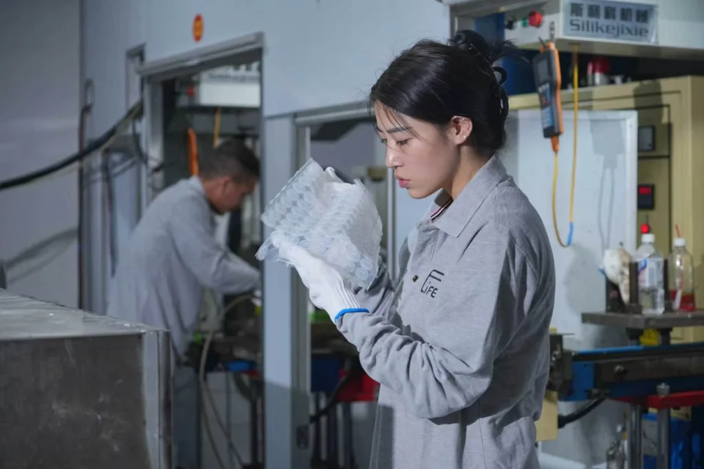 An operator visually inspecting a group of moulded plastic components